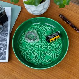 Enamel trinket dish in dark green displayed a camera film roll 