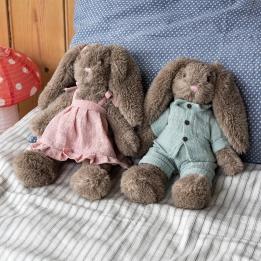 Two plush bunny toys with floppy ears, one wearing blue clothes and one wearing pink clothes.