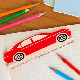A red ruler shaped like a car with measurement markings along the bottom edge
