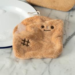 Brown kitchen cloth shaped like a slice of bread with embroidered face and hanging loop