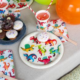 Dinosaur-themed party plate displayes with matching napkins and a cup.