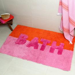 An orange and pink tufted bath mat with the word “BATH” in bold letters.