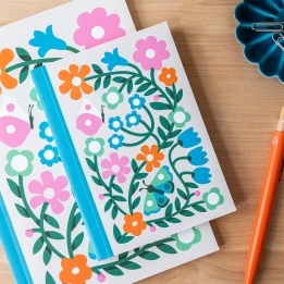 Notebook with colourful illustrated flowers, leaves, and butterflies on the cover.