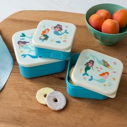 Set of three mermaid-themed snack boxes on a wooden table.