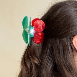 Hair claw clip featuring a sweet cherry design in red, green and white, with hints of marbling and translucence. 