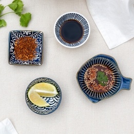 Ceramic dipping bowls shown with soy sauce, chilli flakes and lime wedges.