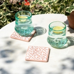 Set of two ceramic drinks coasters featuring an elegant embossed pattern, reminiscent of traditional tile designs.