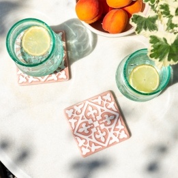 Set of two ceramic drinks coasters featuring an elegant embossed pattern, reminiscent of traditional tile designs.