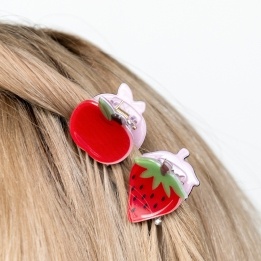 Set of two mini fruit-shaped hair claw clips in strawberry and apple designs.
