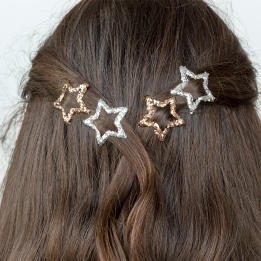 Silver and gold glitter star hair clips in a set of four.