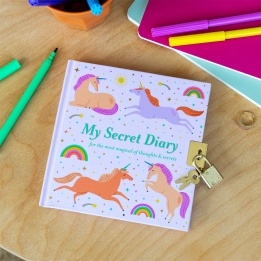 Unicorn-themed secret diary with padlock and keys on a desk with colourful stationery.