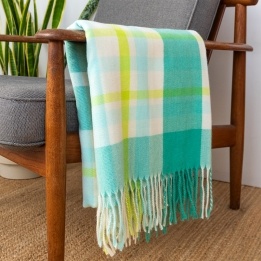 Green, white, lime green and tea check blanket displayed over a wooden armchair