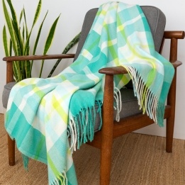 Green, white, lime green and tea check blanket displayed over a wooden chair