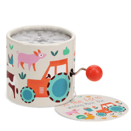 Farmyard‑themed winding music box with illustrated tractor and animals, featuring a red turning handle with tag.