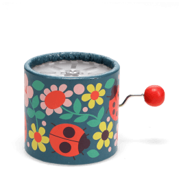 Winding music box with illustrated flowers and ladybird design, featuring a red turning handle.
