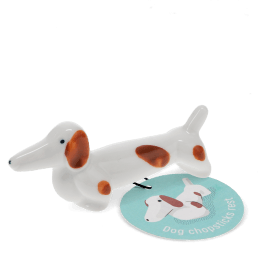 Ceramic sausage dog chopstick rest with brown patches with tag.