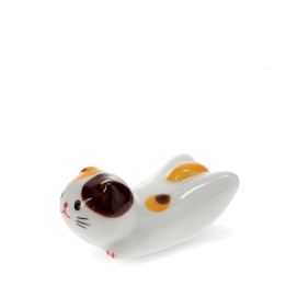 Ceramic cat‑shaped chopstick rest with brown and yellow patches.