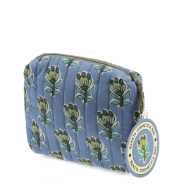 Blue quilted makeup bag with green and blue flowers and a tag.