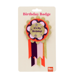 Colourful birthday badge with a gold centre reading ‘It’s My Birthday!’ and ribbons displayed with its packaging.