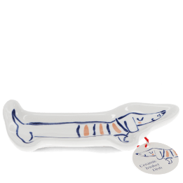 White ceramic trinket dish shaped like a long sausage dog with a tag.