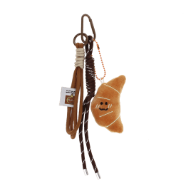 Plush croissant bag charm with brown cord strap and metal clip attachment