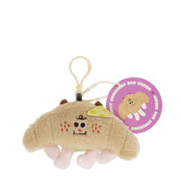 Fluffy croissant bag charm with smiley face, cheese patch and clip attachment with tag.