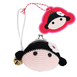 Crochet girl-shaped coin purse with a metal clasp and hanging bell charm with tag.