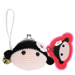 Crochet girl-shaped coin purse with a metal clasp and hanging bell charm with tag.
