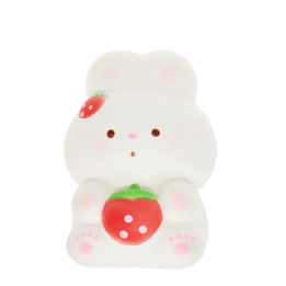 White bunny squishy toy holding a strawberry, with pink paw details and strawberry hair accessory.
