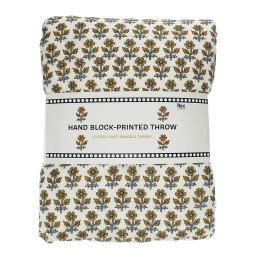 Hand block-printed throw with yellow floral pattern, folded in packaging.