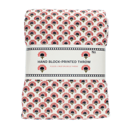 Hand block-printed throw with red floral pattern, folded in packaging.