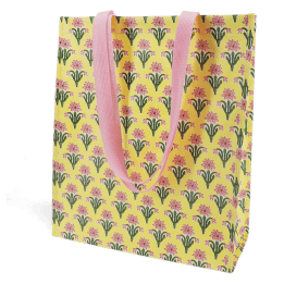 Yellow shopping bag with floral block-print pattern and matching pink carry handles.