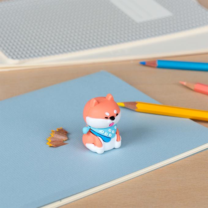 Dog pencil sharpener with coloured pencils placed beside
