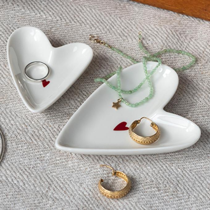 White heart-shaped jewelry dishes with red heart detail, perfect for storing rings, bracelets, and necklaces.