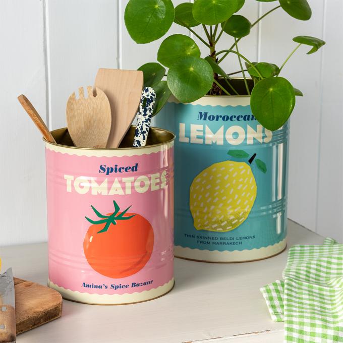 Two large lemon and tomato tins used as utensil holder and plant pot.