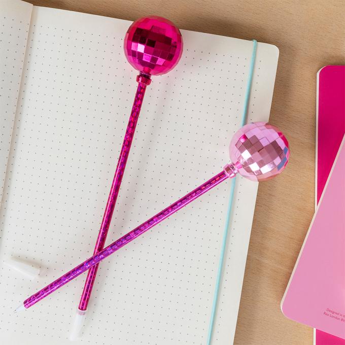 two dsico ball pens in pink placed on a notebook