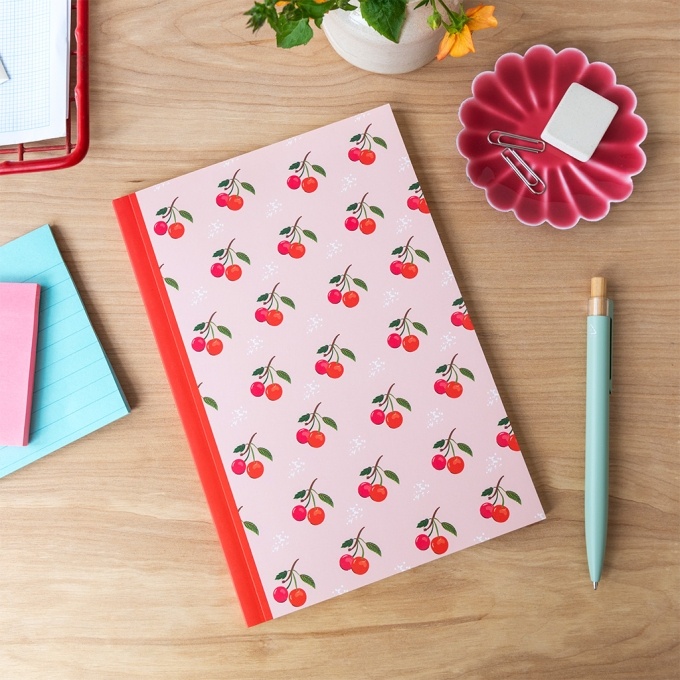 Pink notebook with cherry design on the cover.