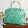 Turquoise oilcloth weekend bag with print of cheetahs