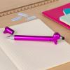 Pink sausage dog stylus ballpoint pen with cap off, lying on a notebook