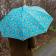 Turquoise umbrella with print of cheetahs used by person outside