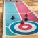 Curling game board with colourful target and brown poop-shaped pieces