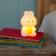 White bunny night light with an orange carrot shown with light on