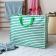 Large jumbo storage bag with green horizontal stripes and green handles.