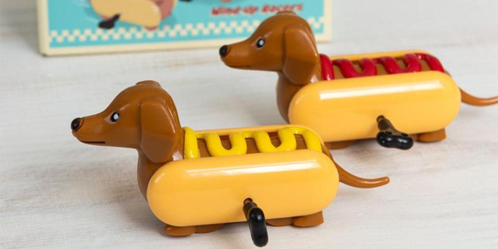 Two wind-ups toys shaped like sausage dogs dressed as hot dogs