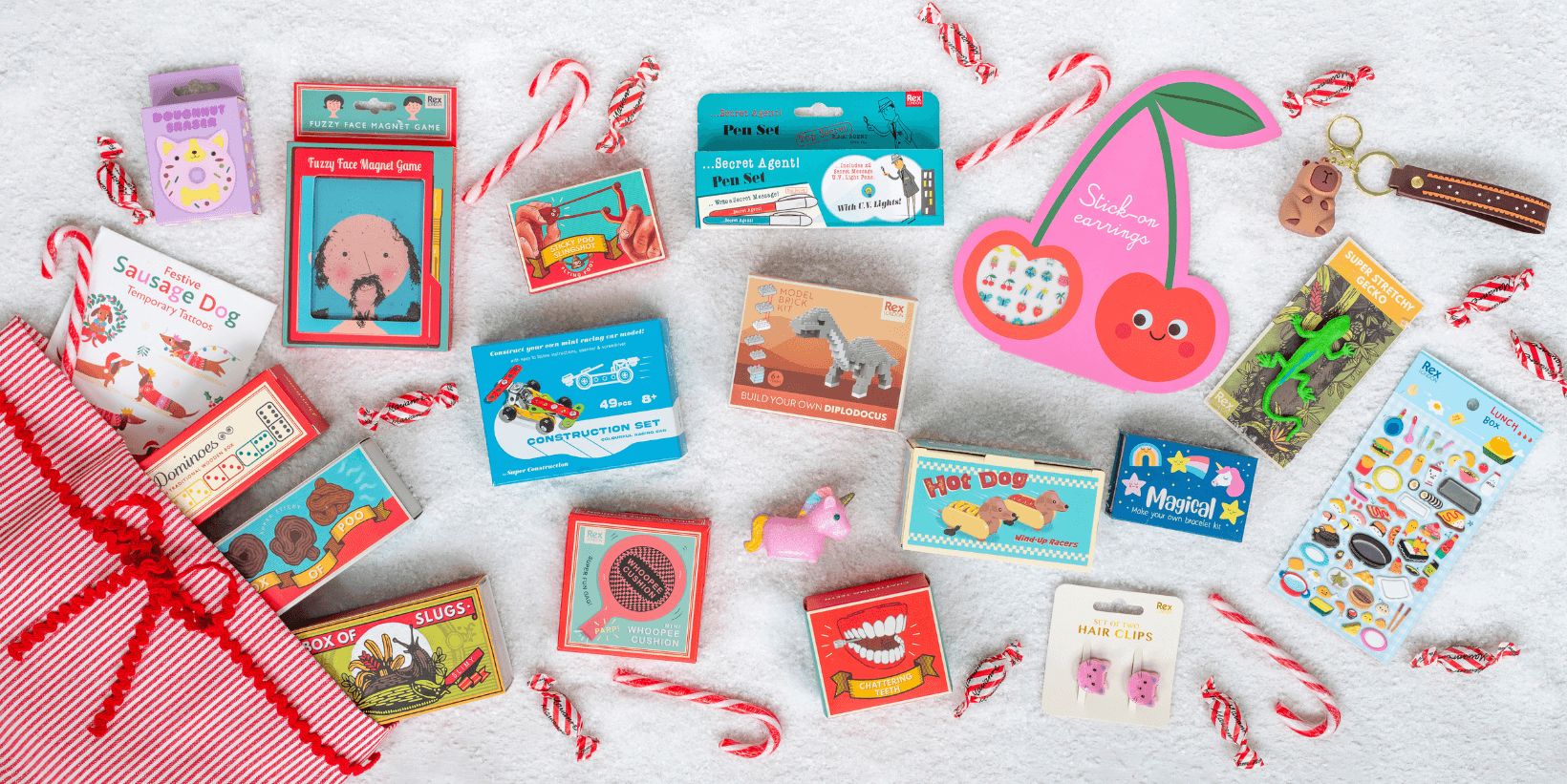 An array of stocking filler toys and games is spread out on a blue cloth