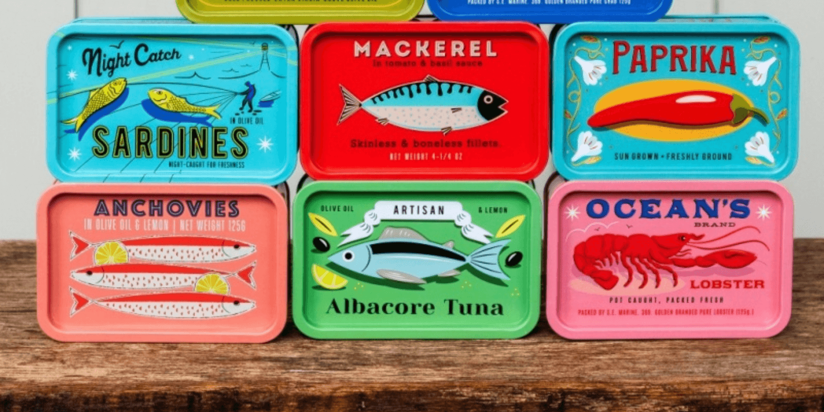 A collection of small square storage tins with retro food designs
