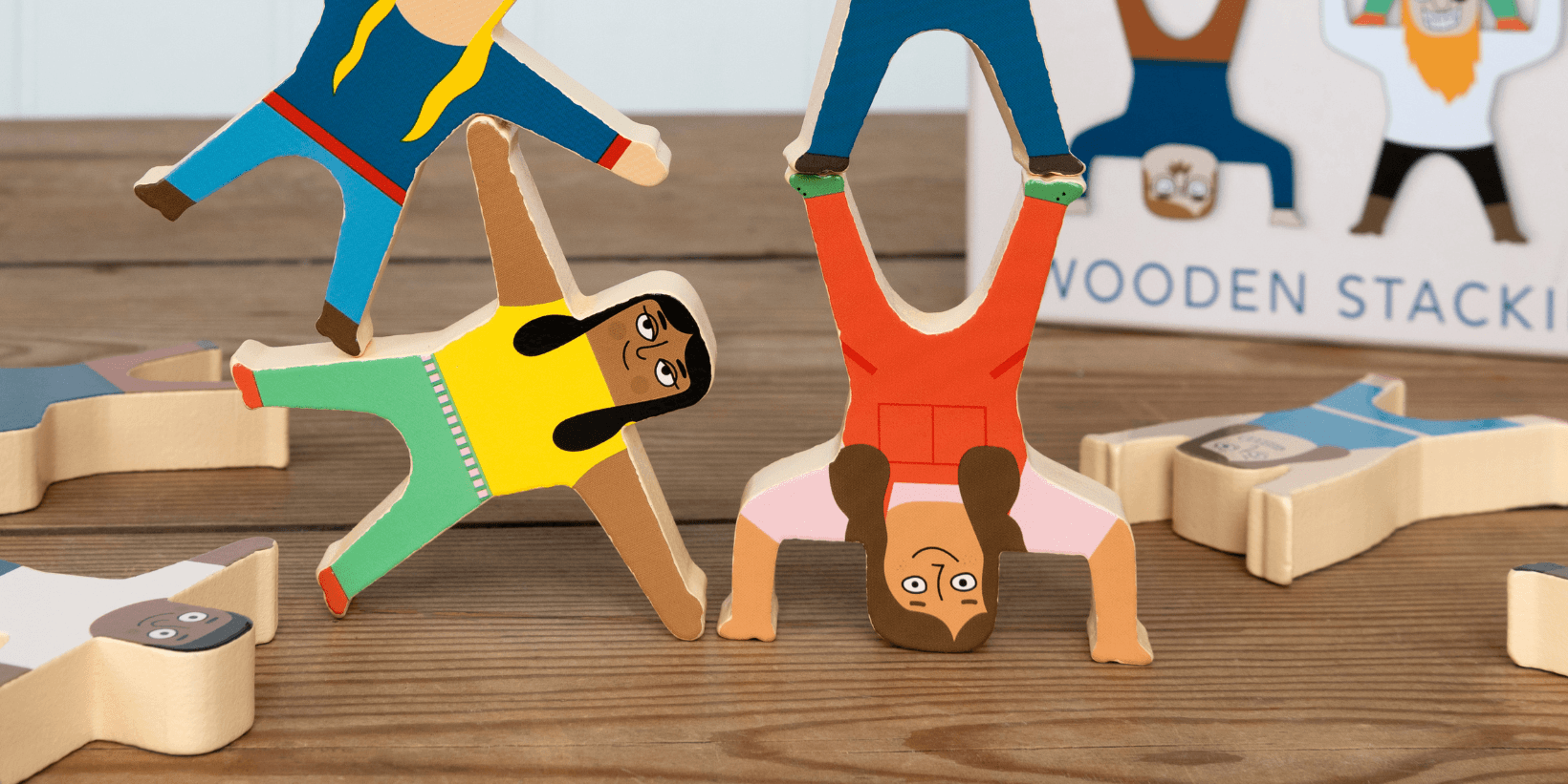Colourful wooden character stacking game with painted wooden figures balanced to form a tower.