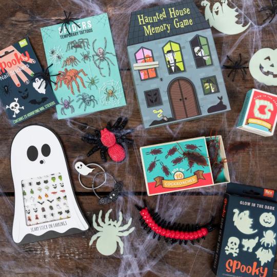 A table is laid with Halloween gifts and fake cobwebs