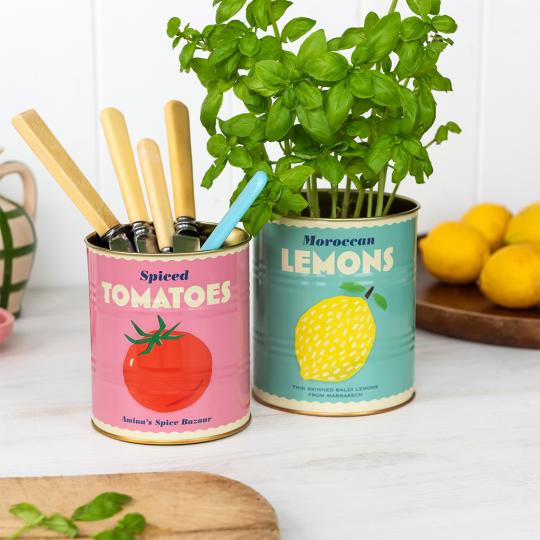 Two lemon and tomato tins repurposed as herb and utensil holders 