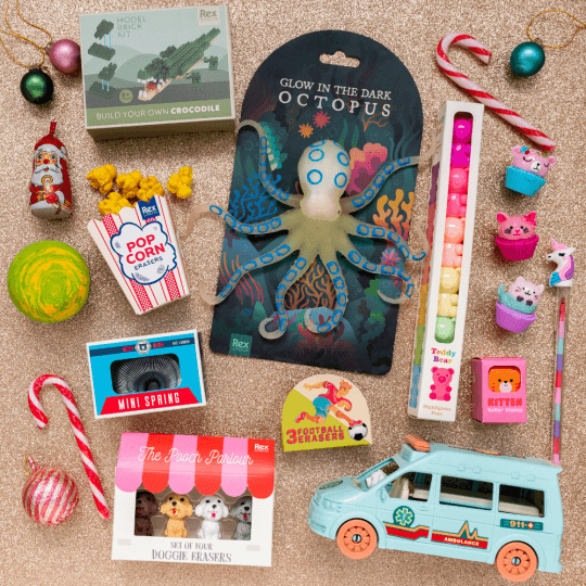 A flat lay image of little toys, candy canes and baubles